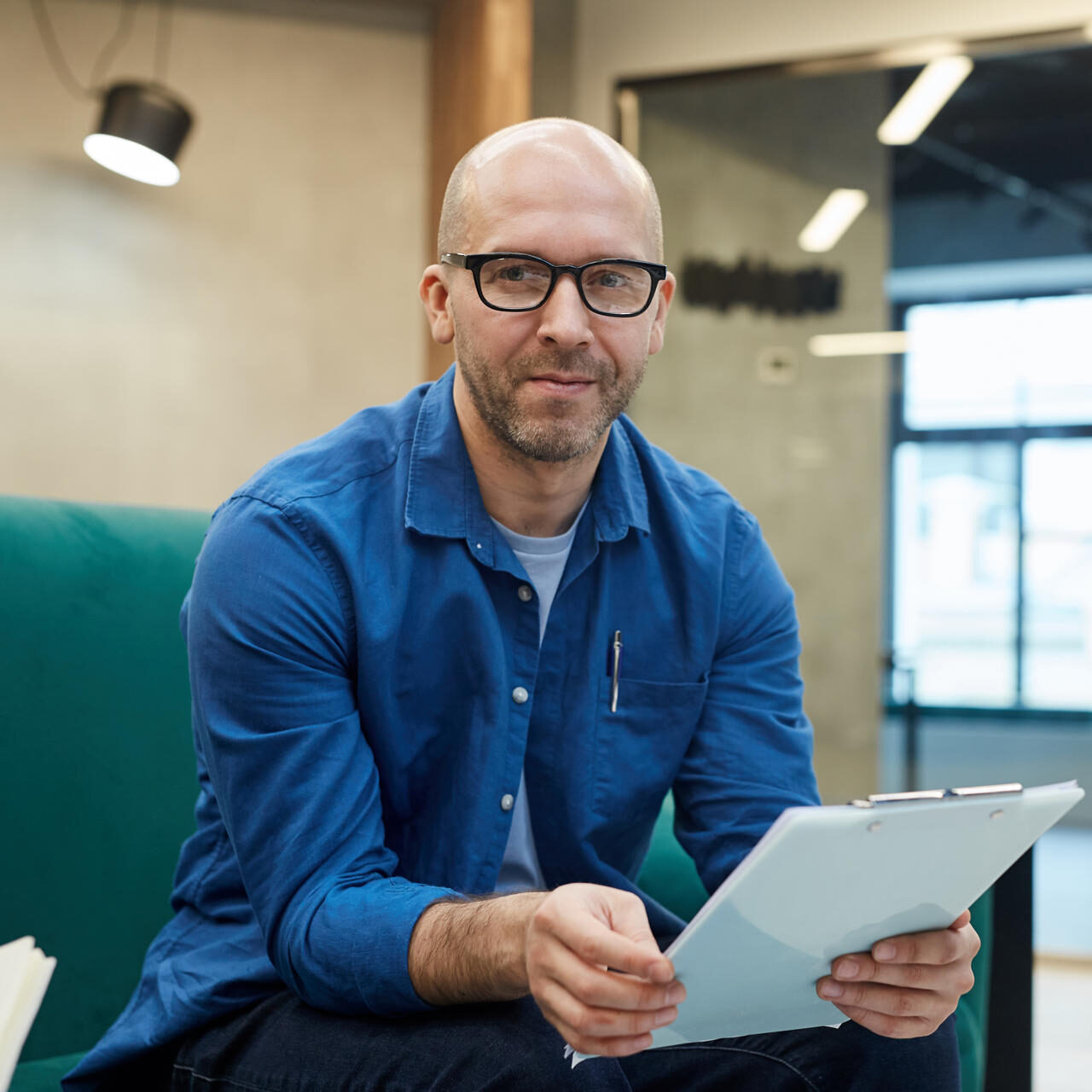 bald-man-holding-clipboard-in-office-2025-03-09-11-30-51-utc-e1750749839303.jpg
